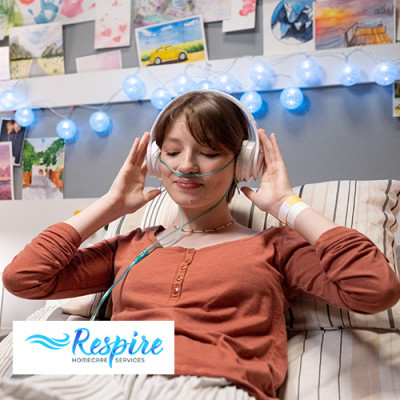 Younger lady using an oxygen concentrator while listening to music in bed